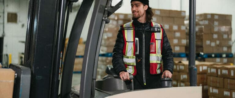A warehouse worker operating a forklift